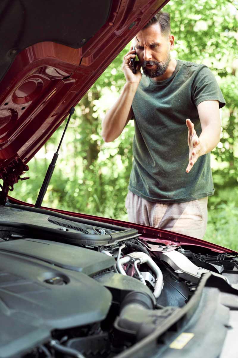 Junger Mann prüft Getriebeschaden bei Schrottauto Ankauf Kiel